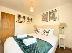 1 dormitorio con 1 cama blanca grande con manta verde en Manchester Apartments by BEVOLVE - City Centre en Mánchester
