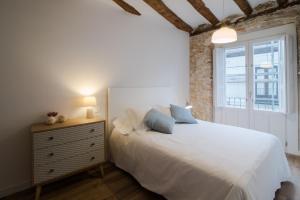 a bedroom with a white bed and a window at Apartamentos Almada in Zaragoza