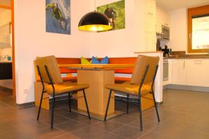 a kitchen with a table and chairs in a kitchen at Verwall 1 Garten FeWo by Alpenfeder in Schruns-Tschagguns +17 photos