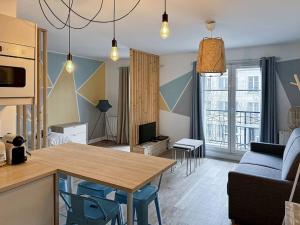 eine Küche und ein Wohnzimmer mit einem Tisch und Stühlen in der Unterkunft Appartement Delta Bailly in Bailly-Romainvilliers