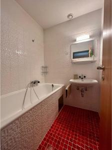 a bathroom with a bath tub and a sink at Apartment A'Horn in Sankt Johann in Tirol