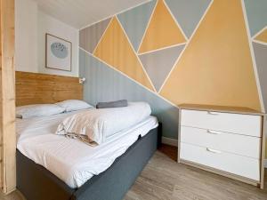 ein Schlafzimmer mit einem Bett mit einer geometrischen Wand in der Unterkunft Appartement Delta Bailly in Bailly-Romainvilliers