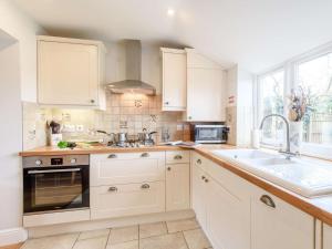 una cocina con armarios blancos y fregadero en 1 Bed in Lyndhurst NFL60 en Lyndhurst