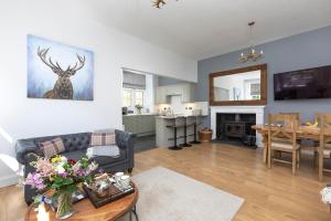 uma sala de estar com um sofá e uma mesa em Laundry Cottage: Drumlanrig Castle em Thornhill