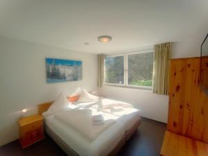 um quarto com uma cama com lençóis brancos e almofadas em Drei Türme 2 em Schruns