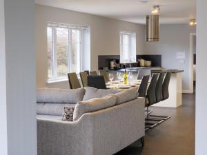 sala de estar con sofá y mesa con sillas en Braeside - Family home in Nethy Bridge en Nethy Bridge