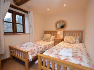 2 Betten in einem Schlafzimmer mit einem Spiegel und einem Fenster in der Unterkunft 4 Bed in Bewdley OSHIP in Highley