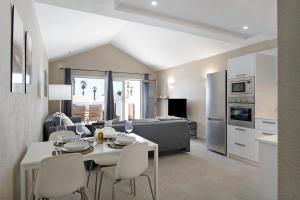 Una cocina y una sala de estar con mesa y sillas. en Playa Flamingo 19, en Playa Blanca