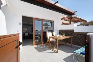 a patio with a wooden table and chairs on a house at Playa Flamingo 19 in Playa Blanca