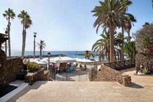 un complejo con palmeras y el océano en el fondo en Playa Flamingo 19, en Playa Blanca