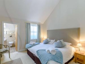 een slaapkamer met een groot bed en handdoeken bij 3 Bed in Thirsk 40351 in Carthorpe