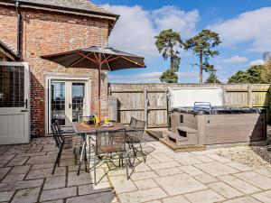 a patio with a table with an umbrella and a grill at 3 Bed in Taunton BLABA in Oake