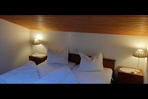 1 dormitorio con 2 camas con sábanas blancas y 2 lámparas en Ferienwohnung Tschagguns Top 5, en Schruns