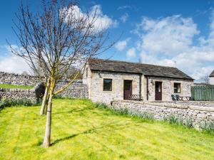 a stone cottage with a tree in the yard at 1 Bed in Ashford in the Water PK574 in Great Longstone