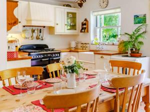 a kitchen with a wooden table with chairs and a dining room at 2 Bed in Sway NFL43 in Sway