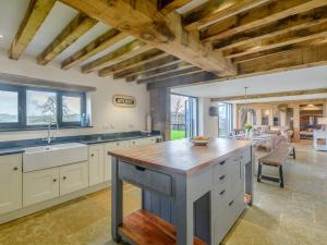 a large kitchen with white cabinets and a wooden ceiling at 5 Bed in Tiverton 48151 in Cadeleigh