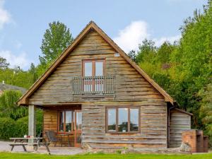 a log cabin with a balcony on top of it at 3 bed in Worcester CC037 in Clifton upon Teme