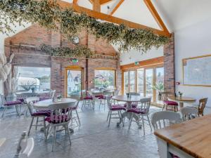 a dining room with tables and chairs and a brick wall at 3 bed in Worcester CC037 in Clifton upon Teme