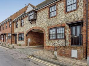 3 Bed in Broadstairs 47658 في برودستيرز: مبنى من الطوب مع ممر على شارع