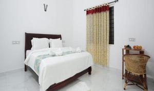 een slaapkamer met een groot bed en een stoel bij FabHotel Prime Moon Hill Resorts in Munnar
