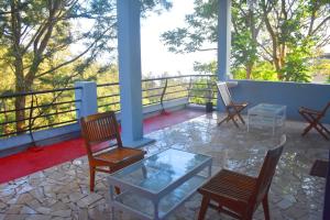 a porch with rocking chairs and a glass table at Vacation villa in Yercaud
