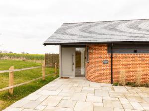 a brick building with a white door and a fence at 2 Bed in Eye 51468 in Wortham