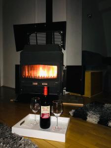 - une bouteille de vin et deux verres de vin devant une cheminée dans l'établissement Pet Apartment, à Strumica