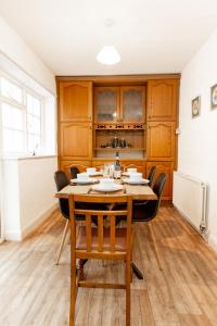 uma sala de jantar com mesa e cadeiras em 3BR Cottage in the Heart of Cheadle em Baguley
