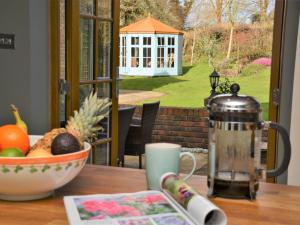 a table with a coffee pot and a bowl of fruit at 4 Bed in Dorchester 56025 in Piddletrenthide