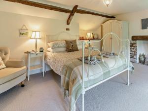 a bedroom with a white bed and a chair at 3 Bed in Brecon 56811 in Llangynidr