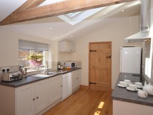 una cucina con armadietti bianchi e lucernario di 3 Bed in Cheddar 58129 a Burrington