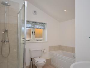 a bathroom with a toilet and a shower and a sink at 3 Bed in Cheddar 58129 in Burrington