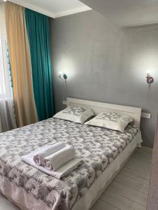 a bedroom with a bed with towels on it at Молодежка in Almaty