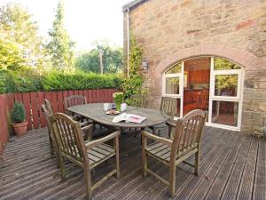 una mesa de madera y sillas en una terraza de madera en 4 Bed in Nr Bamburgh CN201, en Warenford