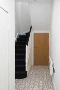 a hallway with a staircase and a wooden door at Erne a Rest in Enniskillen