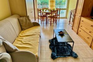 a living room with a couch and a table at L'Orée de Camargue Studio avec Cour in Le Grau-du-Roi