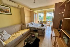 a living room with a couch and a table at L'Orée de Camargue Studio avec Cour in Le Grau-du-Roi