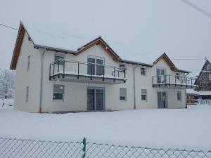 uma casa na neve com uma cerca em Haus Kellenburg em Albstadt