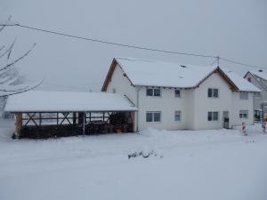 a white house with snow on the roof at Haus Kellenburg in Albstadt