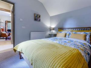 a bedroom with a bed with a yellow comforter at 1 Bed in Gloucester 46502 in Lassington