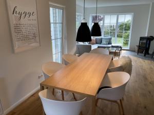 a dining room with a wooden table and chairs at Hus Hygge in Born