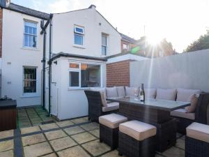 a patio with a table and chairs and a building at Central Victorian terraced house Patio Garden - Pass the Keys in Cheltenham