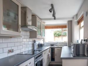 a kitchen with white appliances and a large window at Central Victorian terraced house Patio Garden - Pass the Keys in Cheltenham