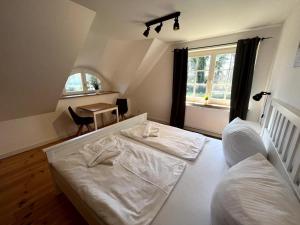 a bedroom with two beds and a table and a window at Ferienhaus Fiete in Wieck in Wieck