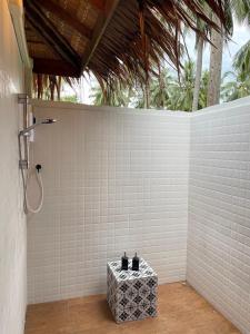 a shower in a white tiled bathroom with a table at COCO Canopy Boutique Resort in Ko Jum