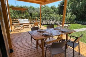 a wooden table and chairs on a wooden deck at Le Dune Villaggio in Lido Di Fondi