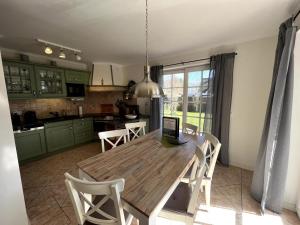 a kitchen with a wooden table with a laptop on it at Ferienhaus Fiete in Wieck in Wieck