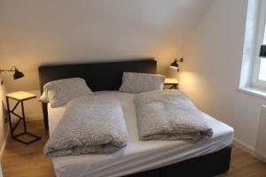 a bed with two pillows on it in a room at Ferienwohnung Lasse in Wieck in Wieck