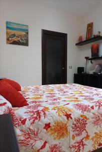 a bed with a colorful comforter on top of it at Antonia & Ivano in Salerno