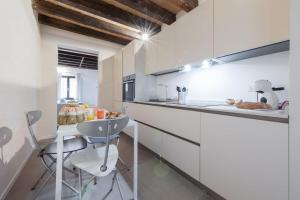 a kitchen with white walls and a counter with a sink at Ca' Ferrando, brand new apartment, experienced host! in Venice
